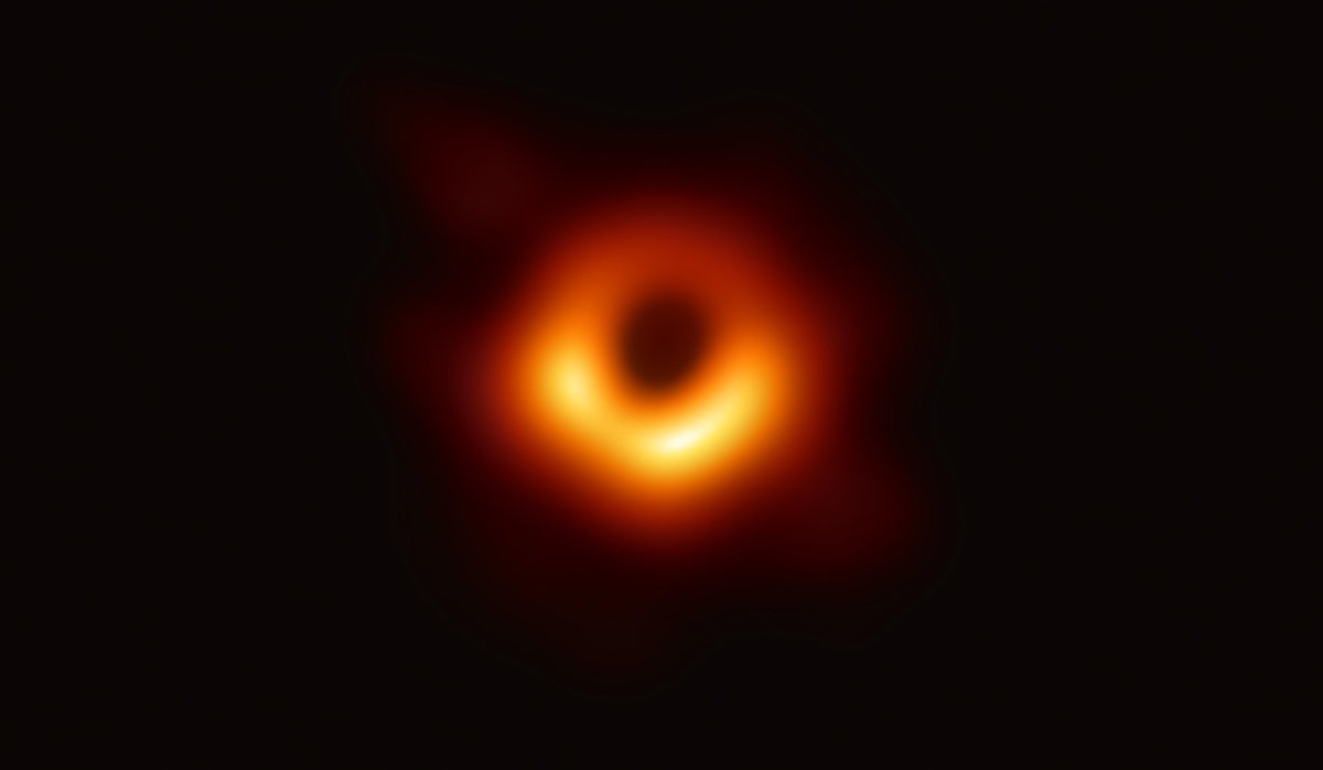 A glowing orange ring of light surrounding a dark central void, depicting a black hole.