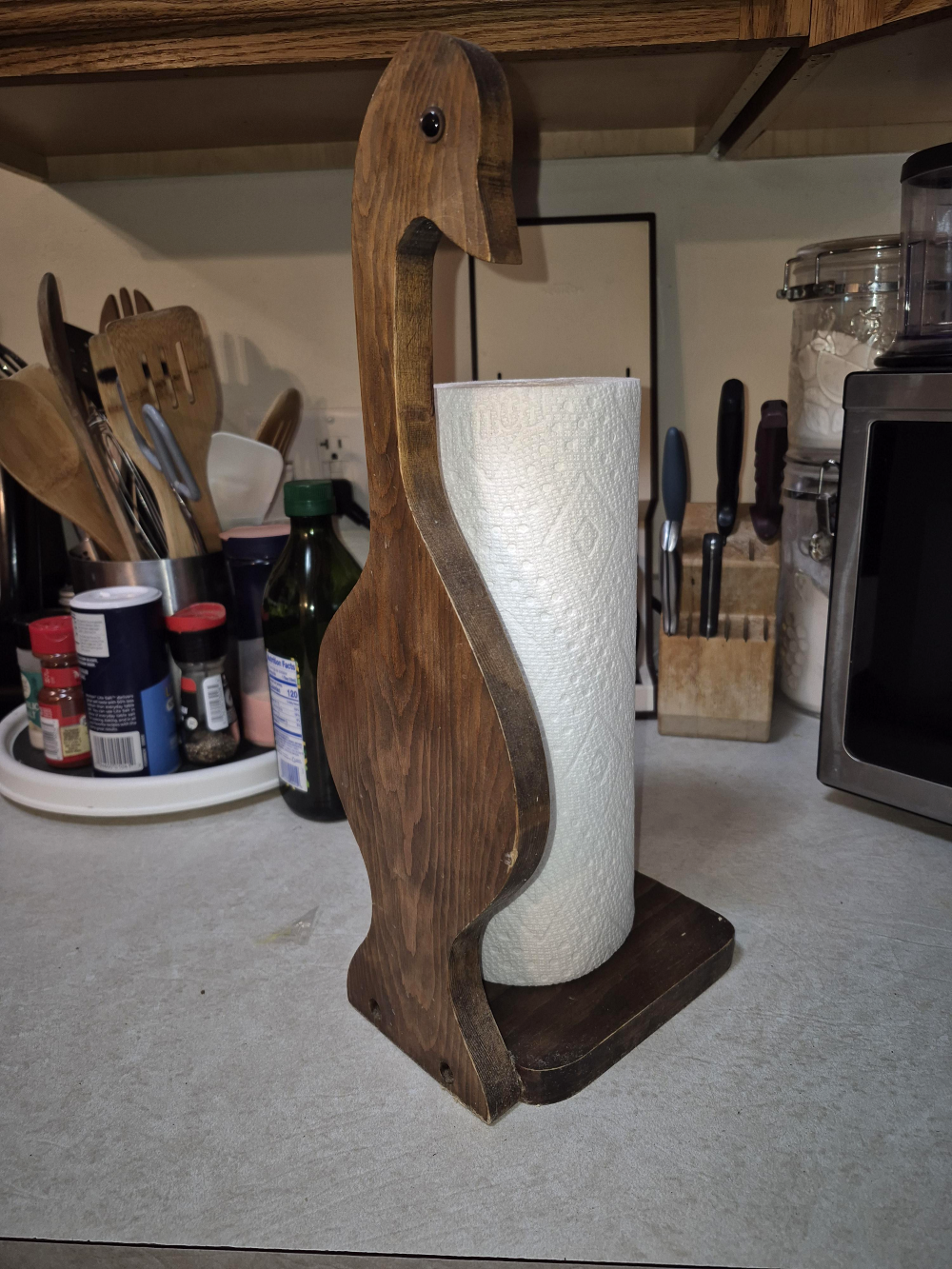 Wooden paper towel holder shaped like a goose.