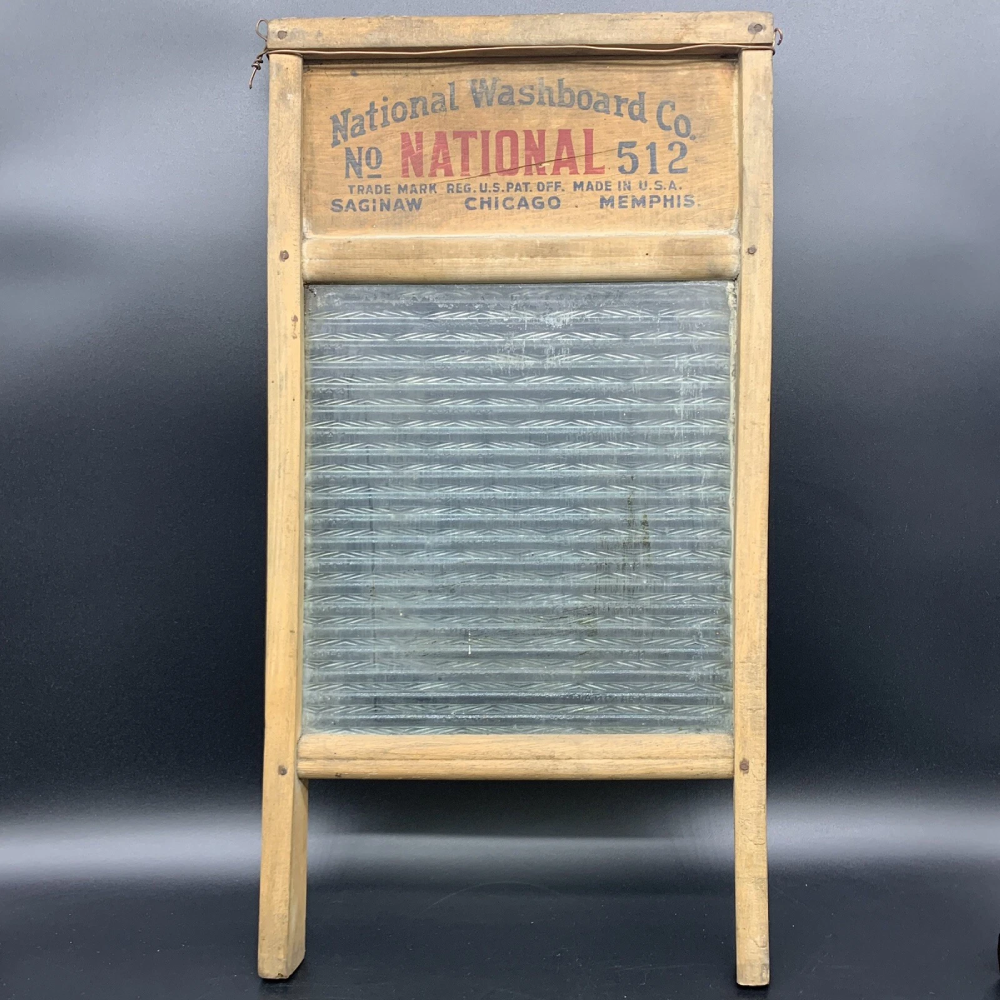 Vintage wooden washboard with a corrugated glass scrubbing surface and a printed label that reads “National Washboard Co. No. NATIONAL 512.”