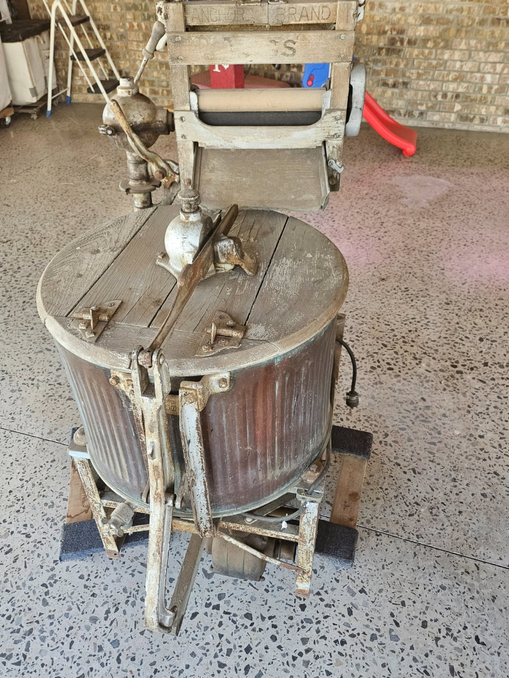 Vintage wooden laundry wringer washing machine with an Anchor Brand logo on top.