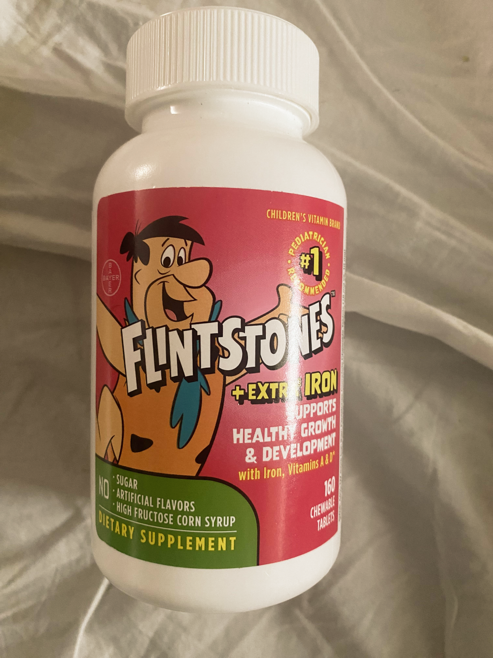 Bottle of Flintstones chewable multivitamin tablets with extra iron, featuring Fred Flintstone on the label.