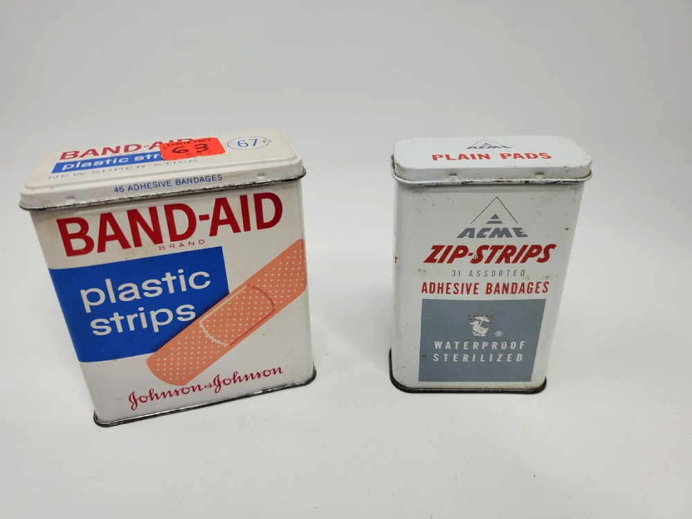 Two vintage metal bandage tins, one for Band-Aid plastic strips and one for Acme Zip-Strips.