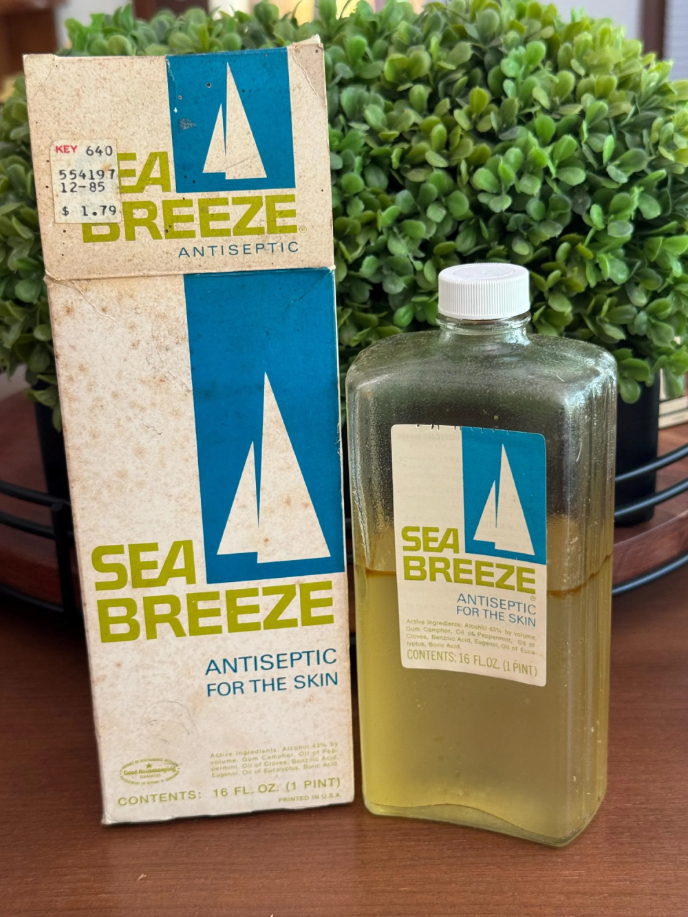 A vintage bottle of Sea Breeze antiseptic and its original cardboard box.