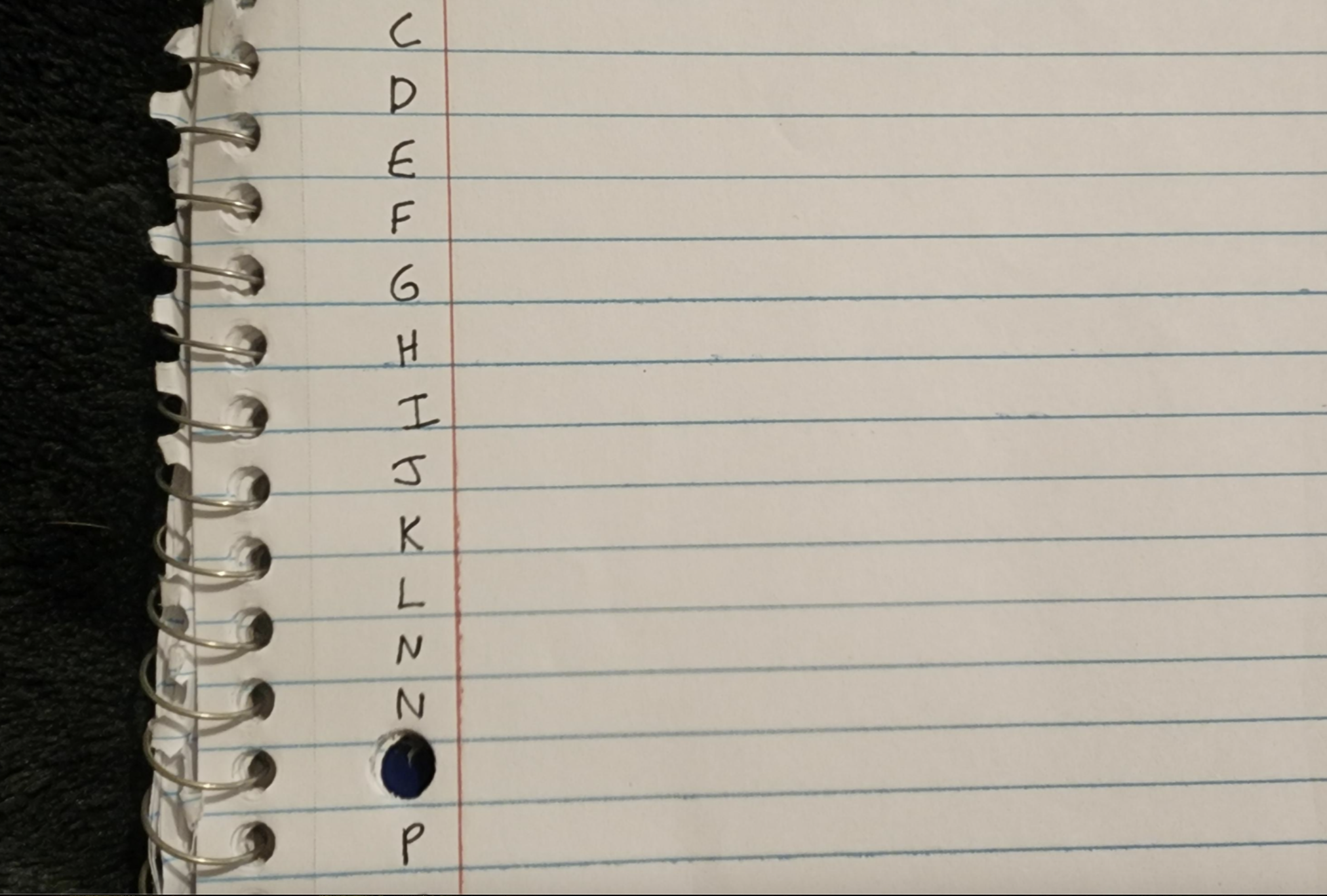 Handwritten letters C through P in alphabetical order on lined notebook paper, with a hole punch mark replacing the letter O.