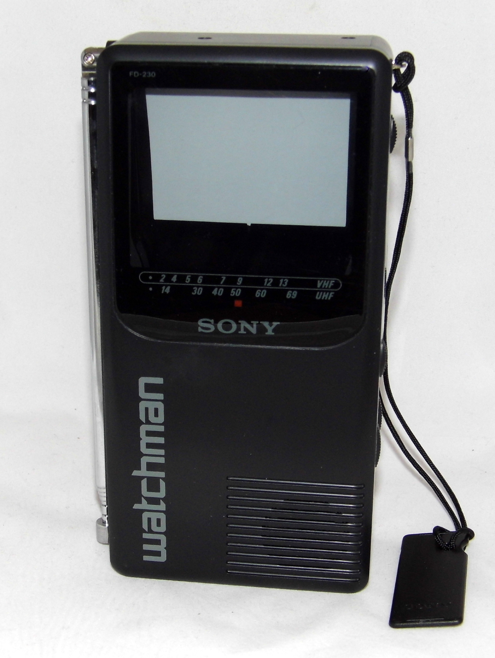 Black Sony Watchman portable television with a retractable antenna and a hanging wrist strap.