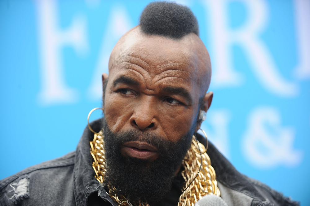 Mr. T with his signature mohawk, beard, hoop earrings, and layered gold chains.