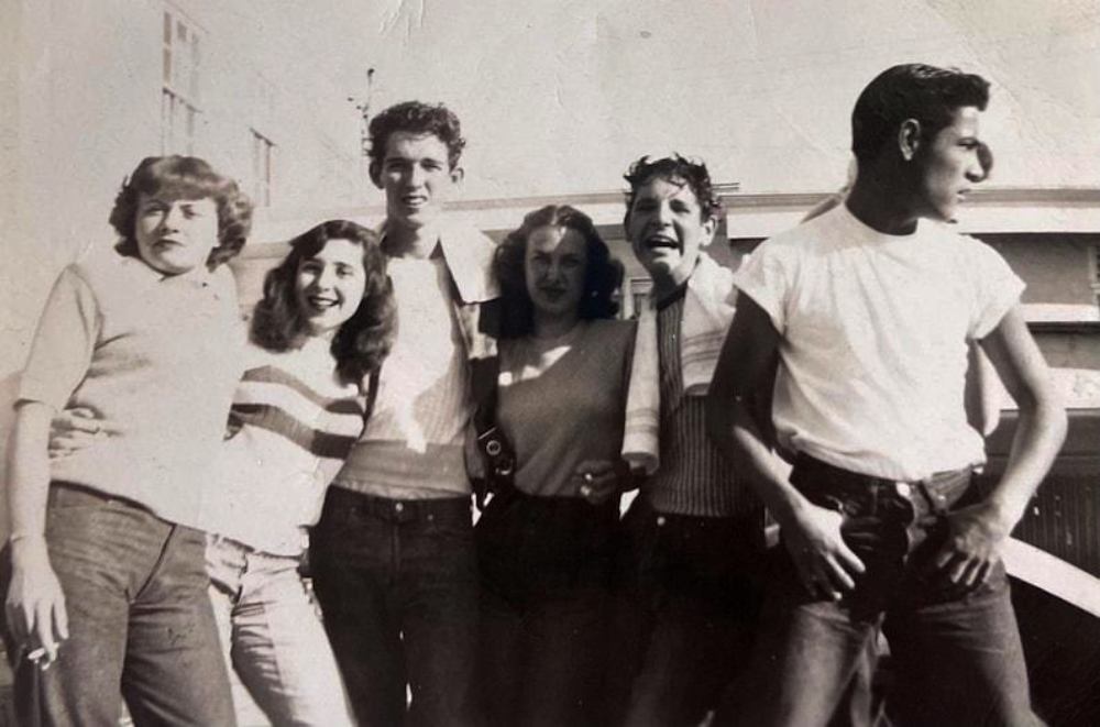 A group of five young people standing together in a vintage black and white photograph.