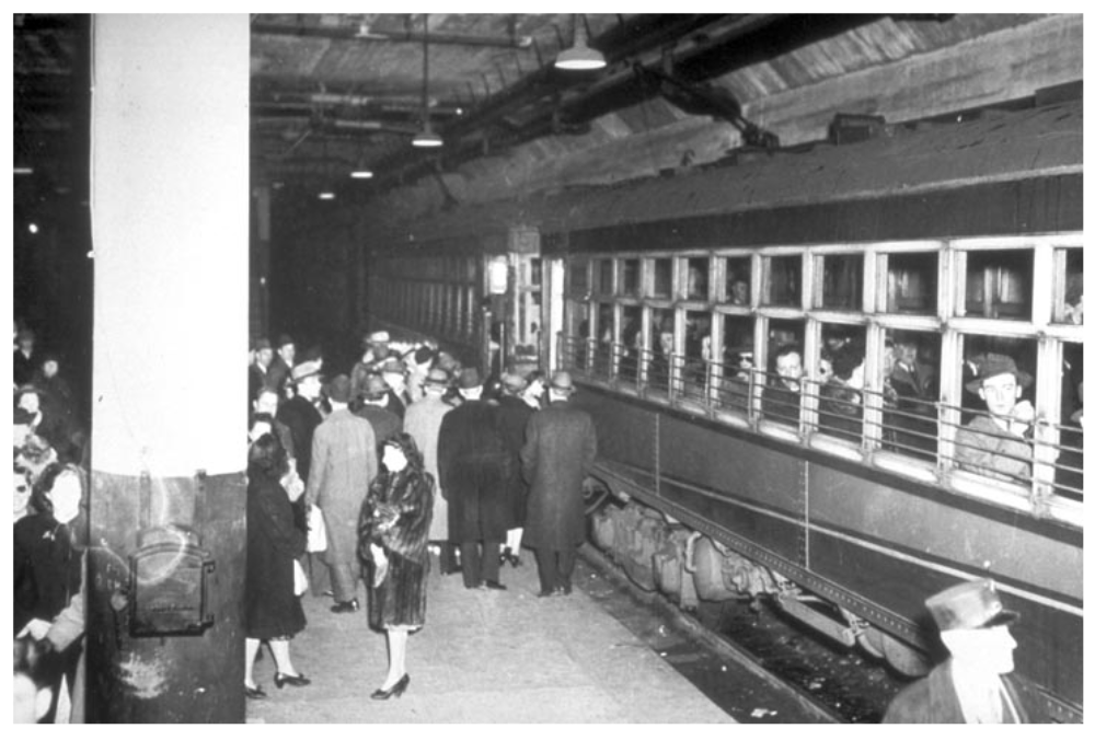 Passengers board a vintage subway train at a station platform.