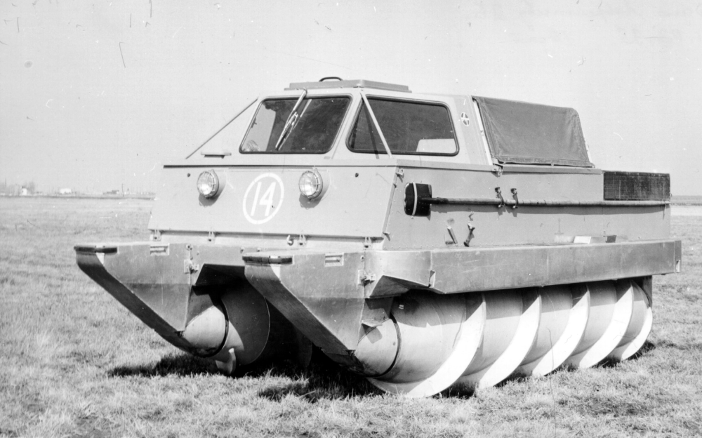 An amphibious screw-propelled vehicle with a cab and two large rotating augers for propulsion, parked in a field.