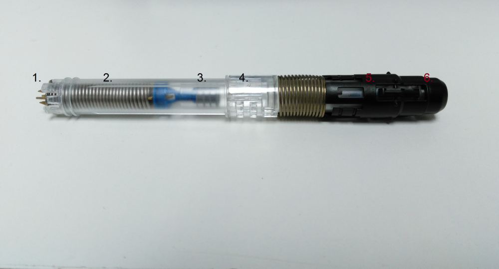 A pen-shaped medical injection device with a clear plastic barrel, metal internal spring, and numbered sections one through six.
