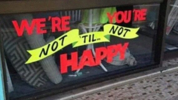 Window sign that reads, “We’re not happy ’til you’re not happy.”